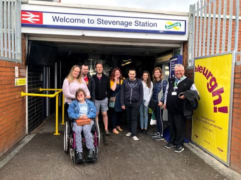 Photograph of a group of people, including one one a wheelchair on a try a train trip to Stevenage Station