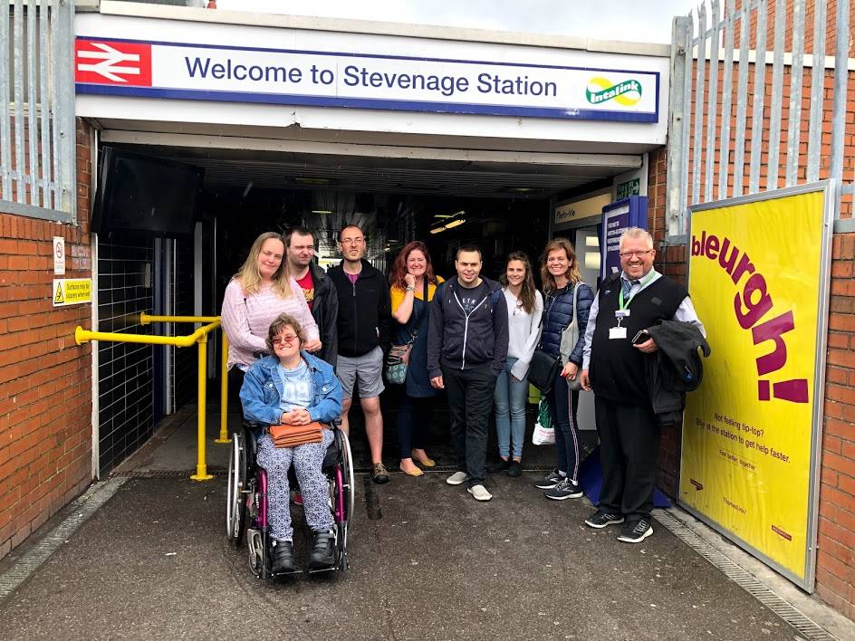 Photograph of a group of people, including one one a wheelchair on a try a train trip to Stevenage Station