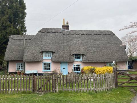 A pink painted thatched cottage in Meldreth